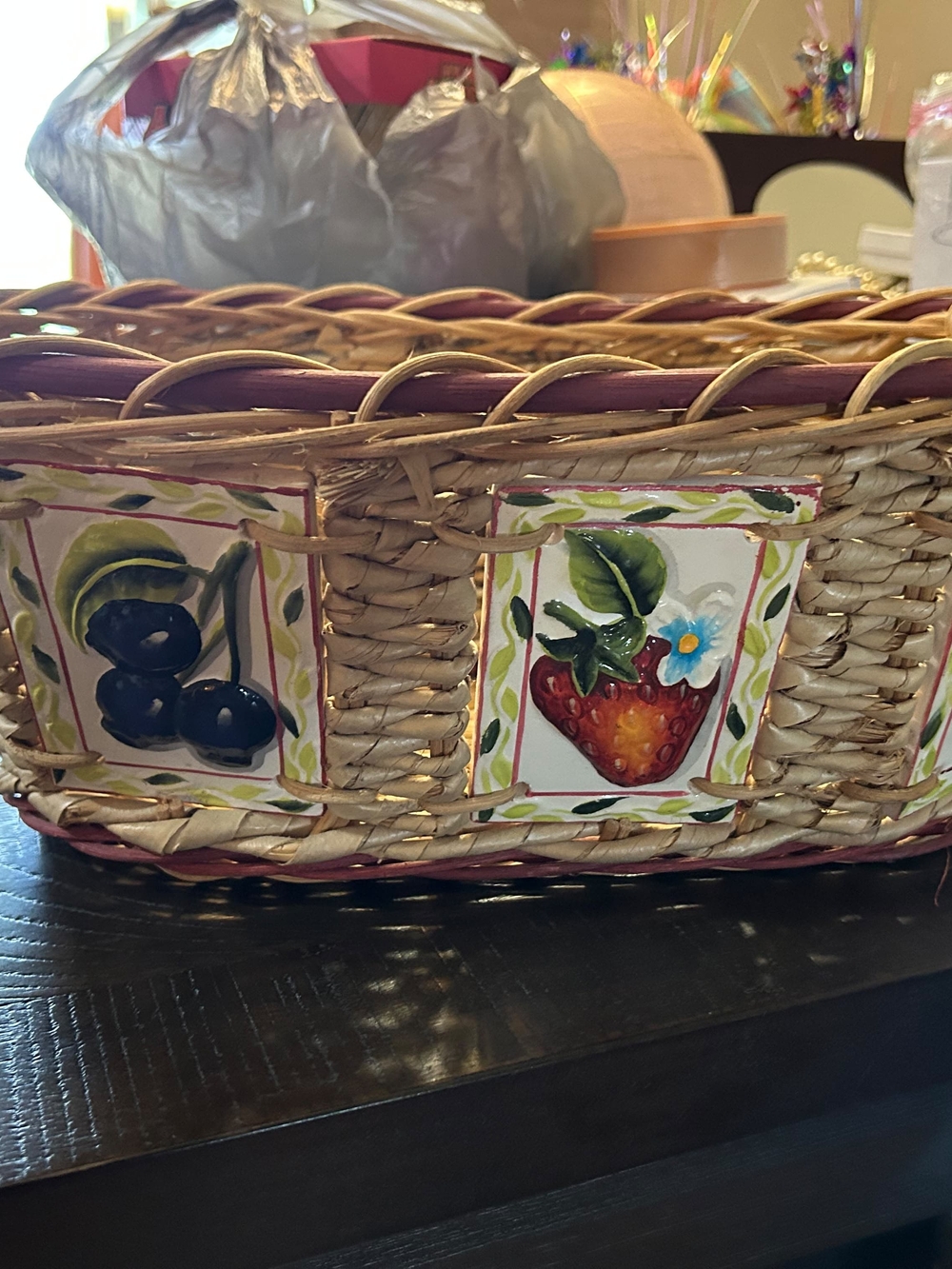 vintage woven wicker basket features hand-painted ceramic fruit tiles.